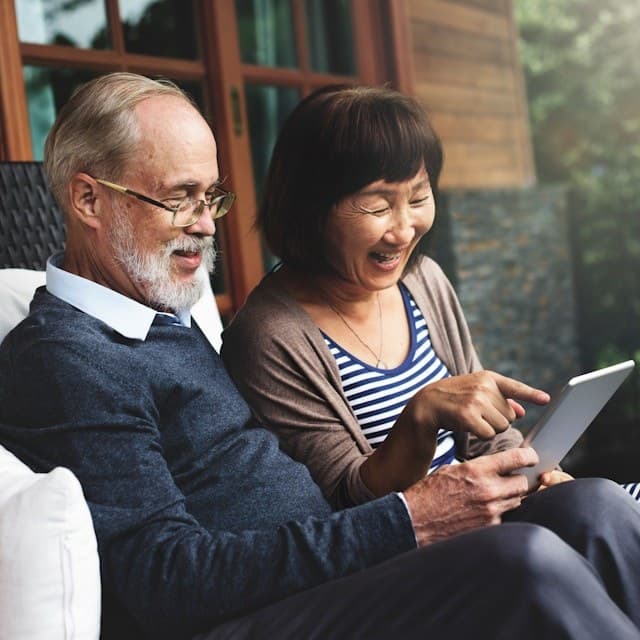 An older couple looking at a tablet together and smiling